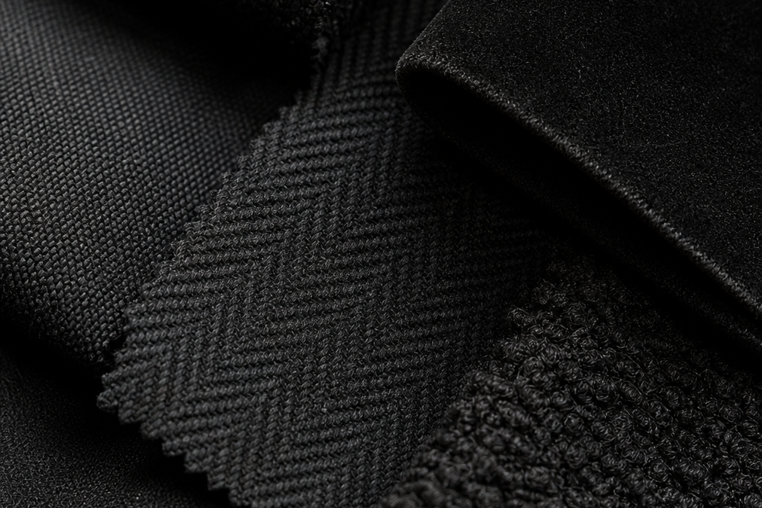 Black upholstery fabric swatches in matte black, charcoal, black velvet, and herringbone for sample-first texture, color, and yardage planning
